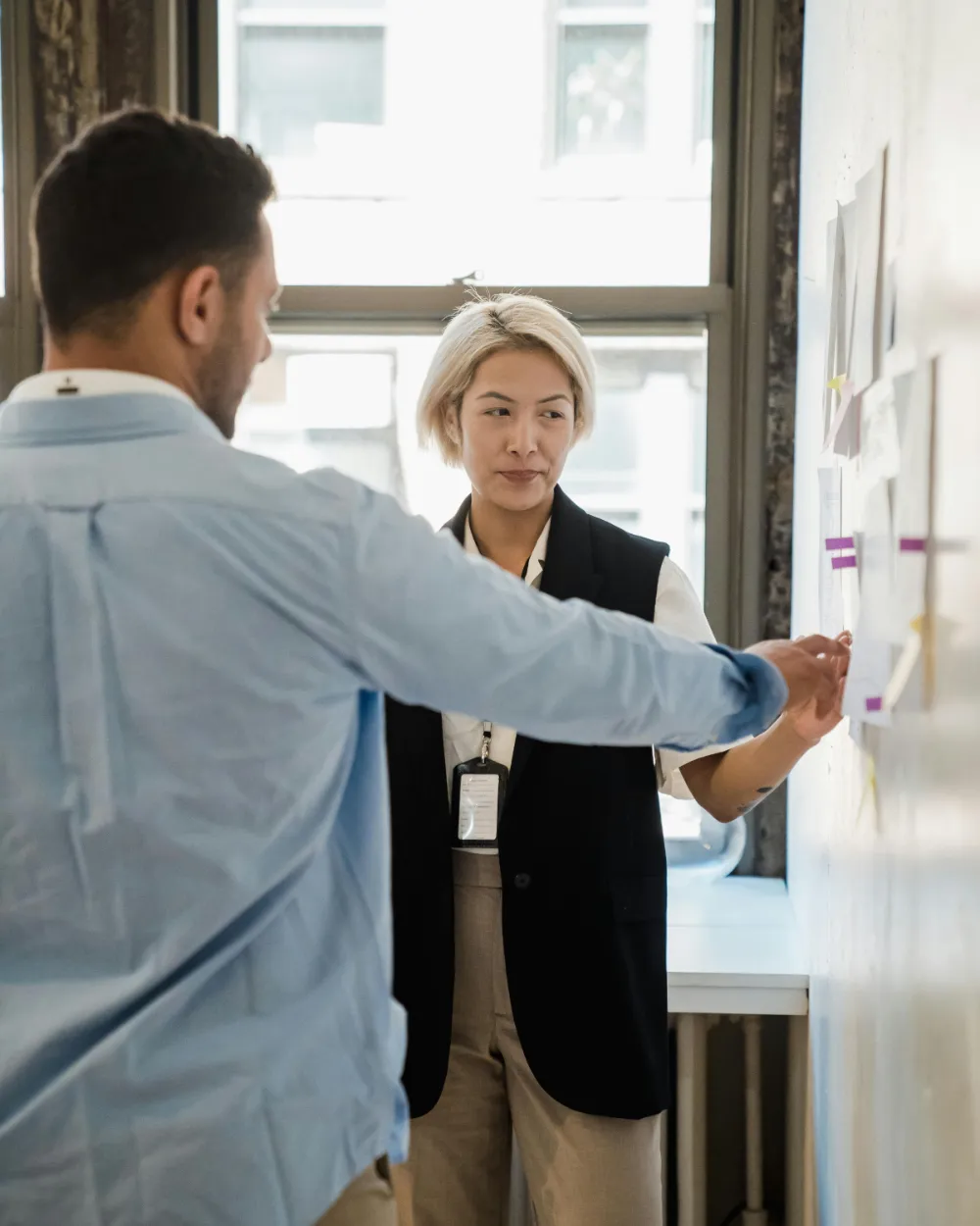 Two colleagues mapping notes on a wall